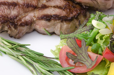 Grilled meat with salad at white plate