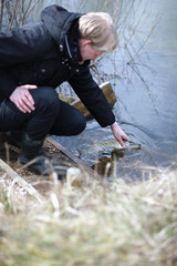 Young man catching a fish bare handed