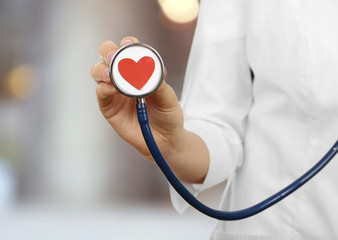 Stethoscope with heart in doctor hand, close up