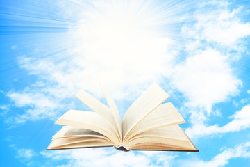 Opened book on sky background