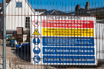 Warning signs at a construction site behind a fence