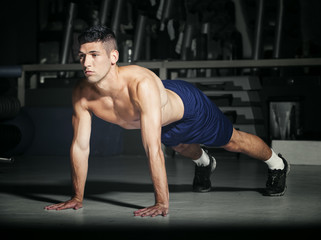 Fototapeta na wymiar Muscular man in gym exercising