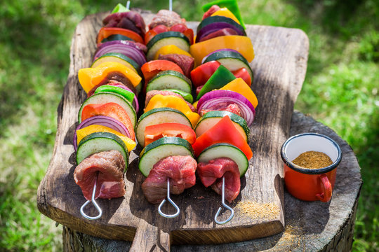 Fresh vegetables and red beef with herbs on grill
