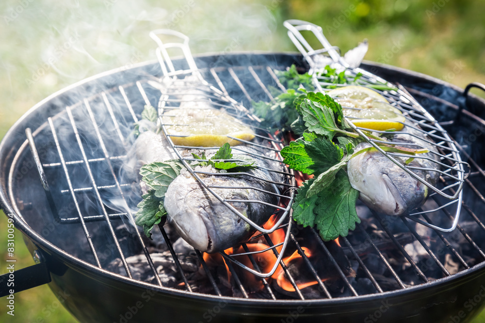 Wall mural grilling fresh fish with lemon and herbs