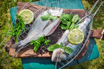 Fototapete Fish Grillen von frischem Fisch mit Kräutern und Zitrone