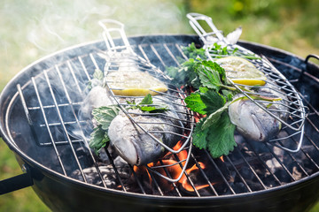 Grilling fresh fish with lemon and herbs