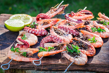 Tasty grilled skewers of seafood with lemon and parsley