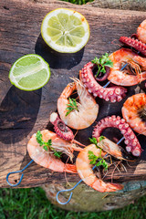 Fresh skewers of seafood with lemon and parsley in garden