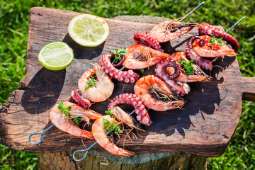 Tasty skewers of seafood with lemon and parsley in garden