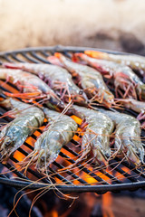 Grilling fresh prawns with lemon and parsley