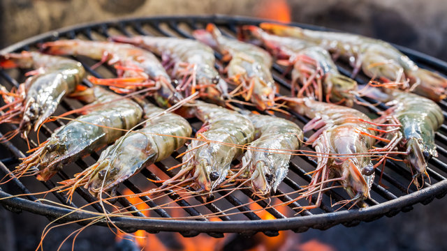Grilling fresh shrimps with lemon and parsley