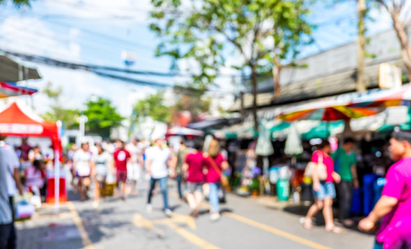 Blurred background : people shopping at market fair in sunny day