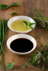 Olive oil, balsamic vinegar and herbs  on wooden background