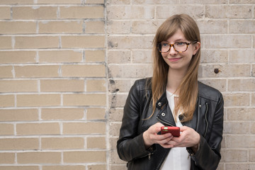 Young caucasian woman in city texting on cell phone