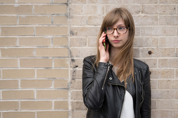 Young caucasian woman in city talking on cell phone