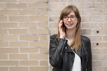 Young caucasian woman in city talking on cell phone