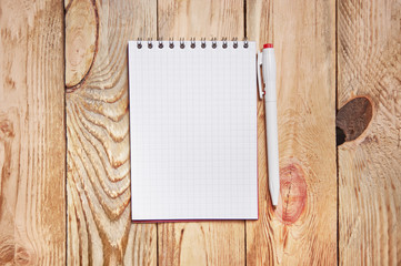 Notebook and pen on the wooden background