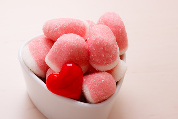 Obraz premium Pink jellies or marshmallows with sugar in bowl