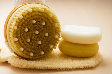 Closeup body brush soap and scrub glove