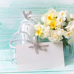 Postcard with daffodils flowers in vase and empty tag for text