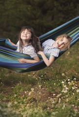 Fototapeta na wymiar The sisters play in a hammock