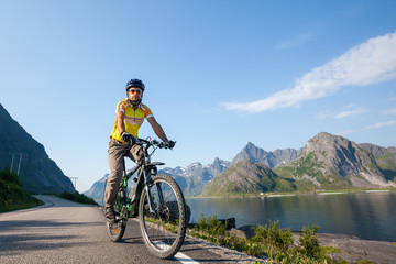Fototapeta na wymiar Biking in Norway against picturesque landscape
