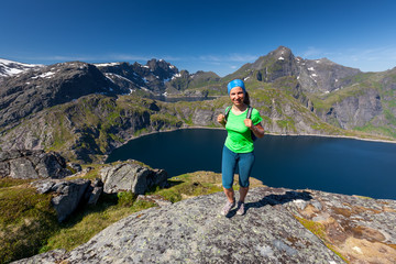Naklejka premium Woman takes rest on top of mountain in Norway