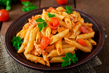 Penne pasta in tomato sauce with chicken, tomatoes