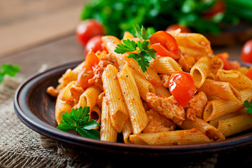 Penne pasta in tomato sauce with chicken, tomatoes - obrazy, fototapety, plakaty