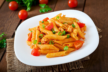 Penne pasta in tomato sauce with chicken, tomatoes