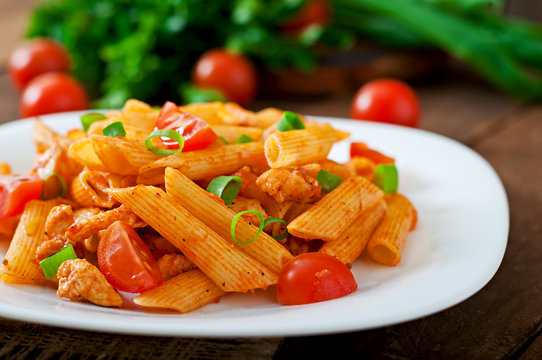 Penne pasta in tomato sauce with chicken, tomatoes