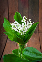 Beautiful wood lilies of the valley on a wooden table