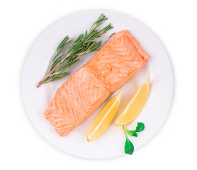 Fried salmon fillet on plate with lemon.