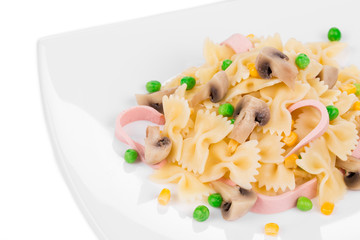 Pasta ribbons with vegetables on white plate.