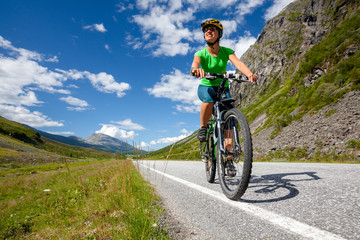 Naklejka na ściany i meble Biking in Norway against picturesque landscape