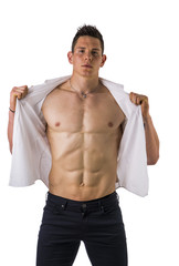 Young man displaying his muscular torso holding open his stylish