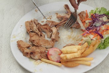 steaks and vegetable salad with french fries.