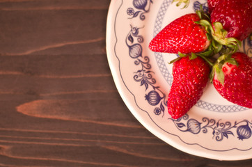 Red strawberry on white and blue plate