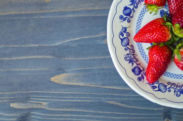 Red strawberry on white and blue plate