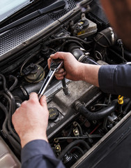 Close up of auto mechanic repairing an engine.