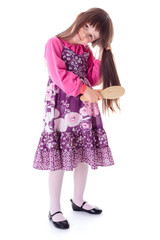 Little girl combing her long hair