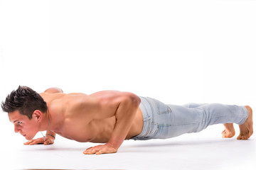 Obraz premium Handsome shirtless bodybuilder doing push-ups in studio shot