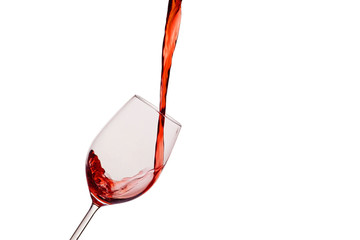 Rotwein wird in ein Weinglas eingegossen