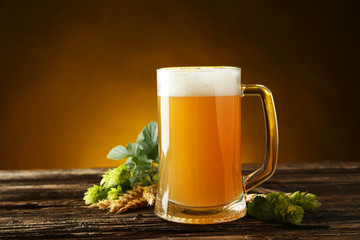 Mug of beer on a brown wooden background