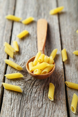 Spoon of pasta on grey wooden background