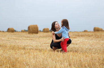 Naklejka na ściany i meble Mom and daughter in a field