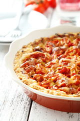 Fresh tomato pie on white wooden background