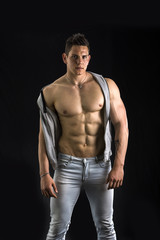 Fototapeta na wymiar Confident, attractive young man with open vest on muscular torso