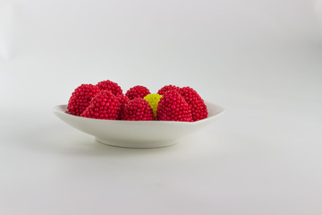 Blackberry jelly red, green, yellow and blue on a white saucer