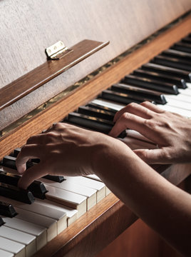 Close up of female hands playing piano